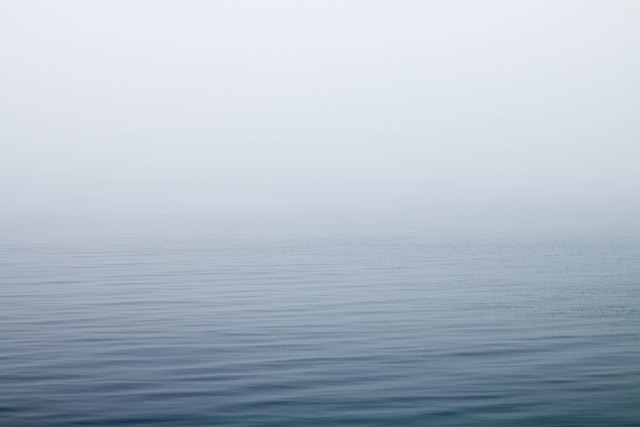 Misty lake at dawn, fog over still water